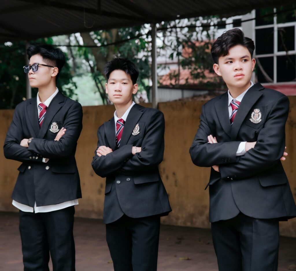 Group of teenagers standing confidently in school uniforms outdoors, showcasing unity and style.